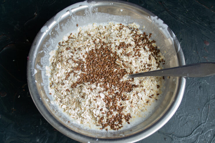 Step 3: Boosting Nutrition with Flax Seeds Flax seeds being poured into the bowl with the oatmeal batter.