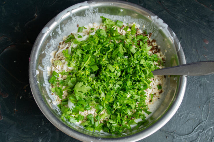 Adding Flavor: Finely Chopped Parsley Fresh parsley leaves being finely chopped for the ovsyanoblin batter.