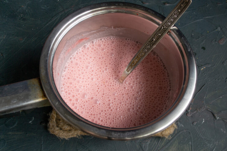Step 8: Whisking the Panna Cotta Mixture Whisking the light pink panna cotta mixture in a saucepan to combine.