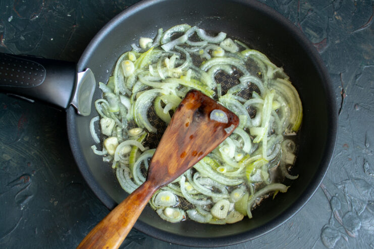 How to Perfectly Sauté Onions and Garlic for Maximum Flavor Sliced onions and garlic being sautéed in a skillet until translucent.