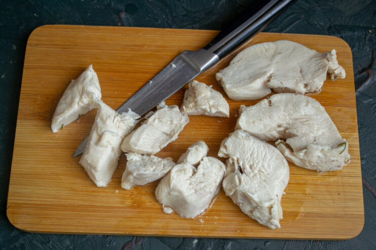 Poaching Chicken Breast to Keep It Juicy for Pâté Coarsely chopped pieces of cooked chicken breast on a cutting board.