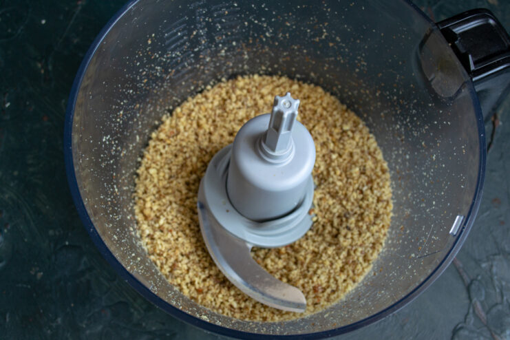Grinding Toasted Walnuts in a Blender Toasted walnuts being ground into a fine crumb inside a blender.