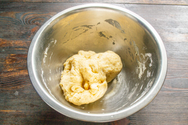 Kneading the Soft and Elastic Pie Dough Hands quickly kneading a soft ball of dough in a glass bowl.