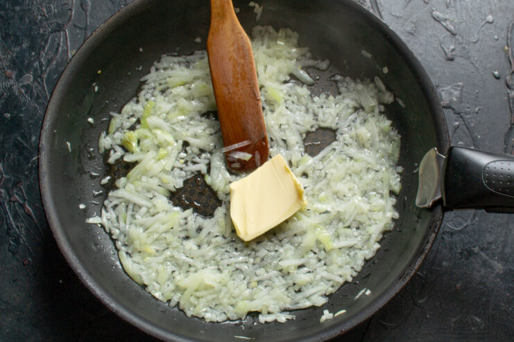 Step 5: Sautéing onions and garlic for the filling Chopped onions and garlic being sautéed in a pan until fragrant.