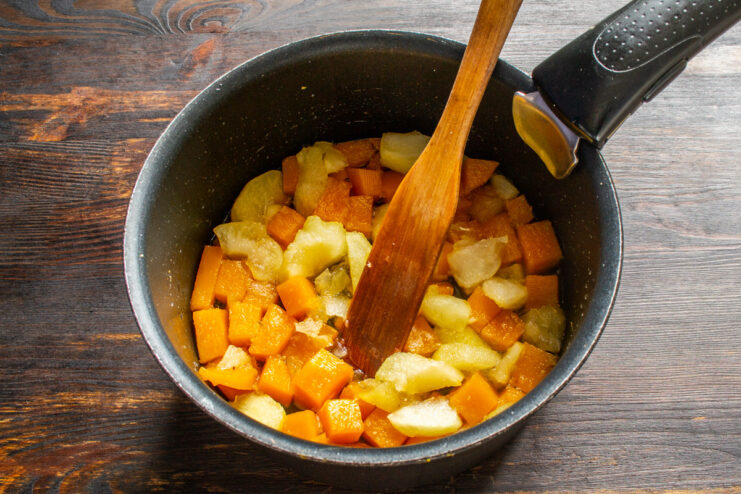Preparing the Filling for the Pumpkin Pie Diced pumpkin and apples simmering in a saucepan to make the pie filling.
