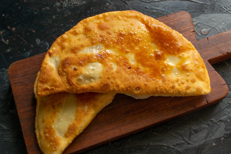 Draining Excess Oil from Freshly Fried Pirozhki Cooked pirozhki resting on a paper towel to absorb excess oil.