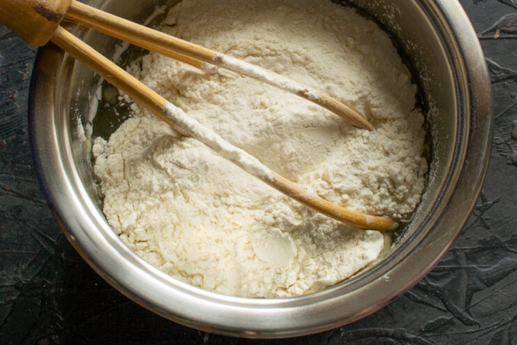 Making the Choux-like Pastry for Pirozhki Whisking flour into a hot liquid in a saucepan to make the dough.