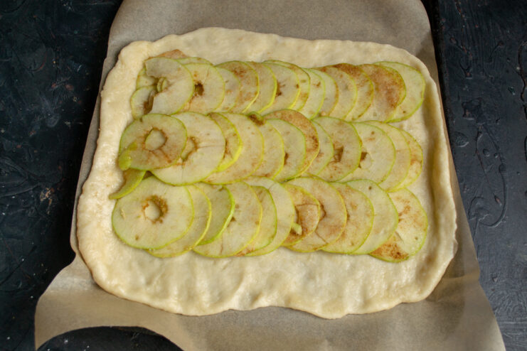 Arranging Apple Slices on the Galette Dough Apple slices arranged in overlapping rows over the center of the dough.