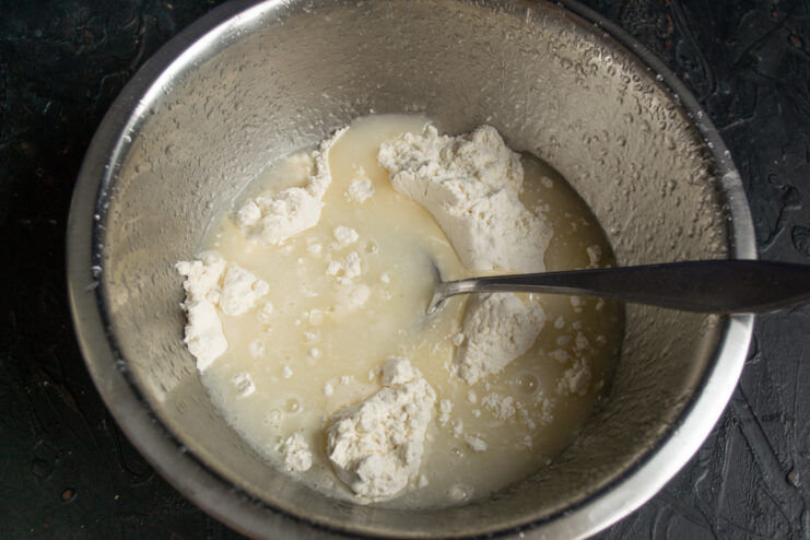 Combining Wet and Dry Ingredients for the Galette Dough Pouring the oil and water emulsion into the bowl of flour.