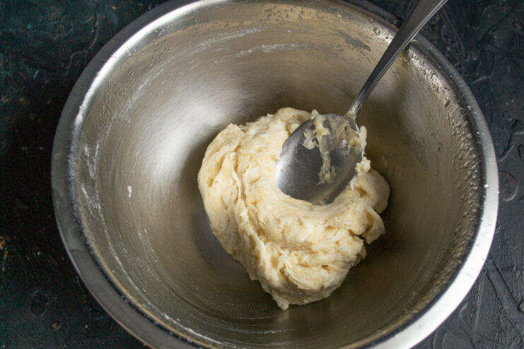 Mixing the Galette Dough with a Spoon A spoon mixing the dough in a bowl until it comes together.