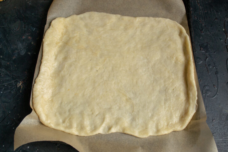 Transferring the Rolled Dough to a Lined Baking Sheet The rolled-out galette dough placed on a parchment-lined baking sheet.