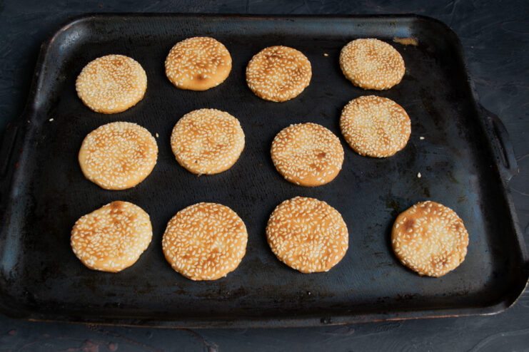 A baking sheet with cookies inside the oven, baking until golden brown.