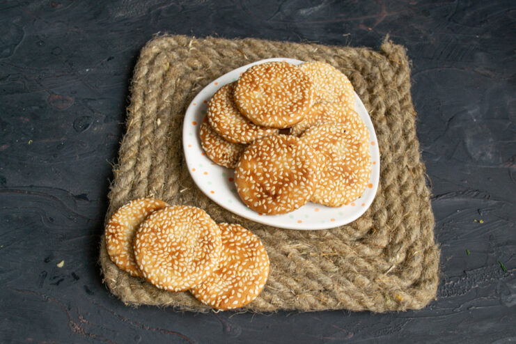 A plate of finished Lenten cookies with pickle brine served next to a cup of tea.