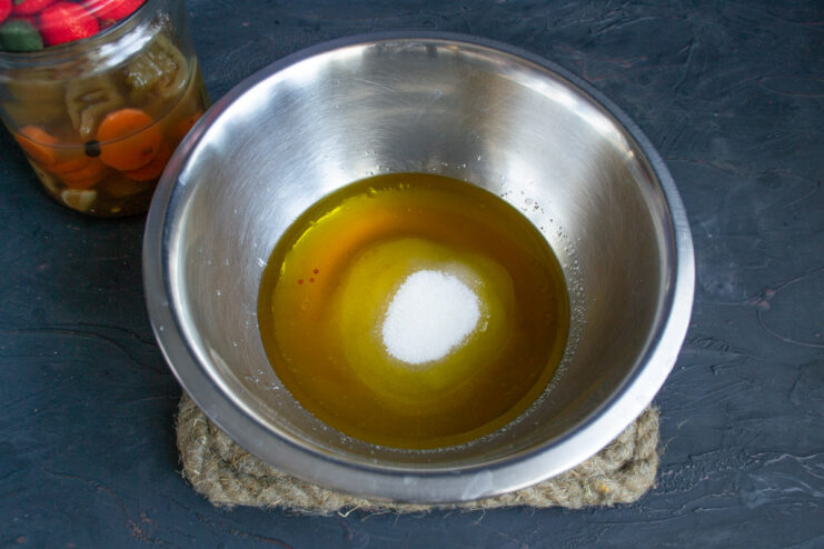 Adding granulated sugar to the liquid ingredients in the bowl.
