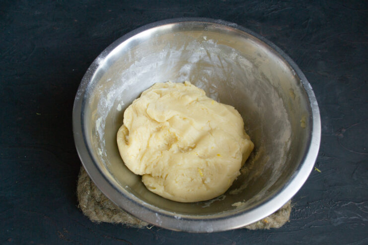 A ball of cookie dough wrapped in plastic wrap, ready to be chilled in the refrigerator.