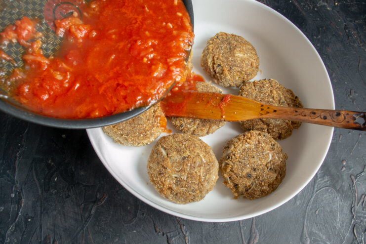 Arranging Fried Patties in a Baking Dish Golden-brown fried cabbage patties arranged in a single layer in a baking dish.