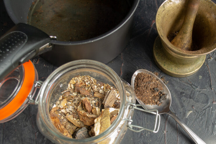 Creating Mushroom Powder for an Umami Boost Dried orange-cap bolete mushrooms being ground into a powder in a mortar and pestle.