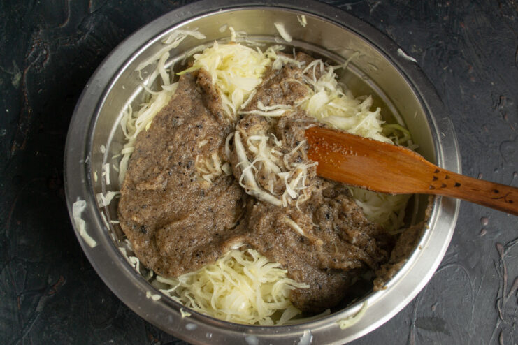 Combining Cabbage with Cooled Semolina A bowl of shredded cabbage with a scoop of cooked semolina being added.