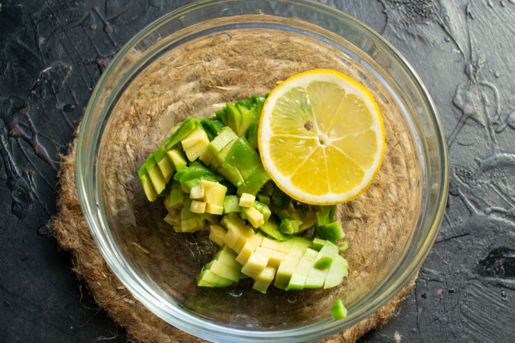 Dicing Avocado Flesh for the Filling A pile of finely diced green avocado flesh in a white bowl.