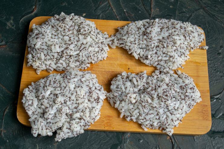 Four equal portions of sticky rice on a wooden board.