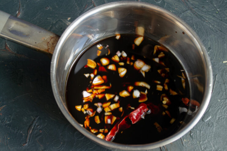 Ingredients for teriyaki sauce, like soy sauce and garlic, in a saucepan.