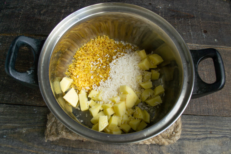 Adding Grains and Potatoes for a Hearty Texture A pot containing chopped potatoes, rice, and bulgur before adding the broth.