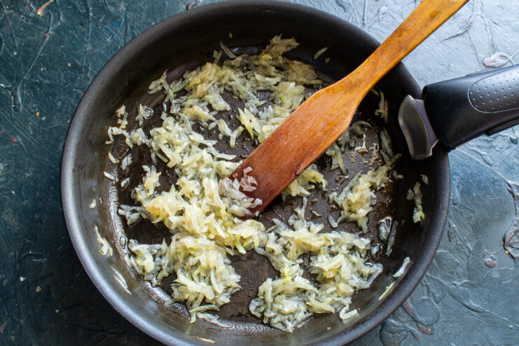 Sautéing Finely Chopped Onions in a Pan Finely chopped onions being sautéed in a pan with butter and oil until soft and translucent.