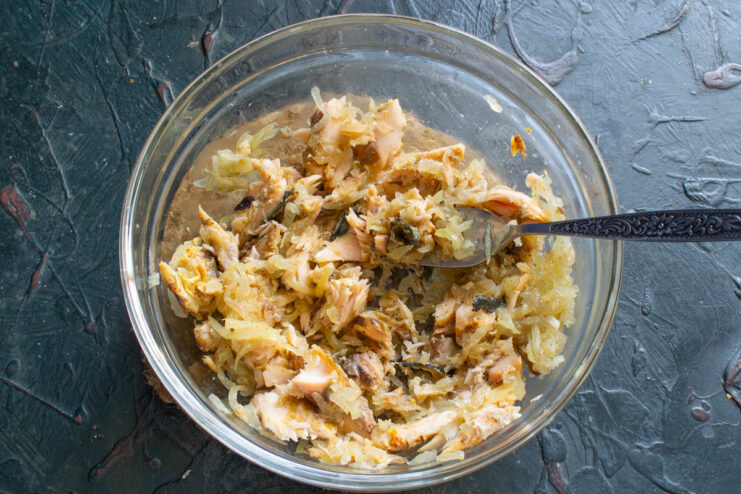 Adding Savory Anchovies to the Salmon Mixture Chopped anchovy fillets being added to the bowl with salmon and onions.