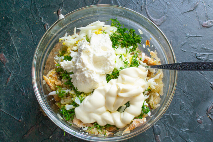 Making the Salad Creamy with Cheese and Mayonnaise Cream cheese and mayonnaise being added to the bowl with the other salad ingredients.