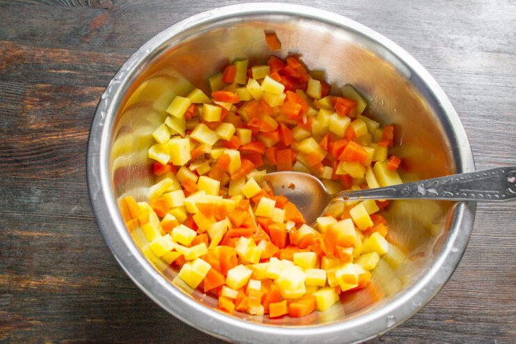 Step 3: Adding the cooled vegetables to a salad bowl. Cooled, cooked vegetables being transferred from a sieve to a glass salad bowl.