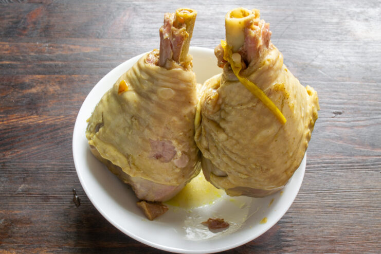 Cooling Cooked Turkey in Broth for Maximum Flavor Cooked turkey drumsticks cooling in a pot of flavorful broth.