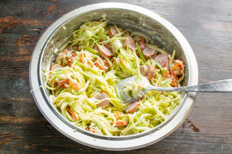 Letting the salad rest to allow the flavors to meld together A bowl of mixed green radish salad resting on a countertop.