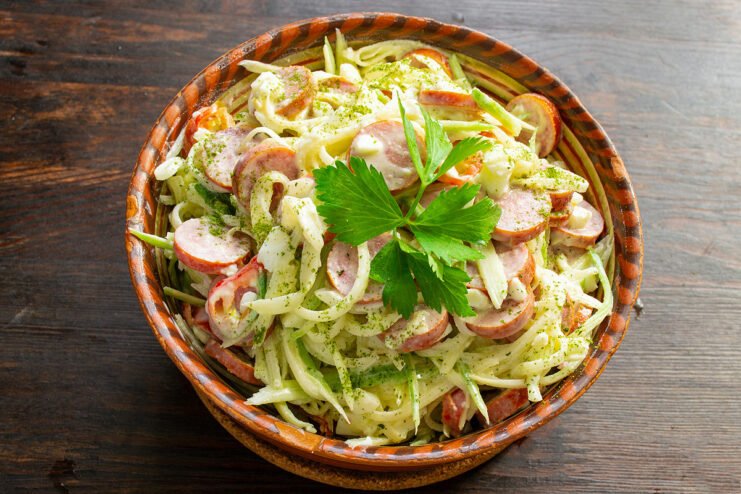 Serve the finished salad with a side of rye bread and enjoy! The finished green radish salad served in a bowl with a side of dark rye bread.