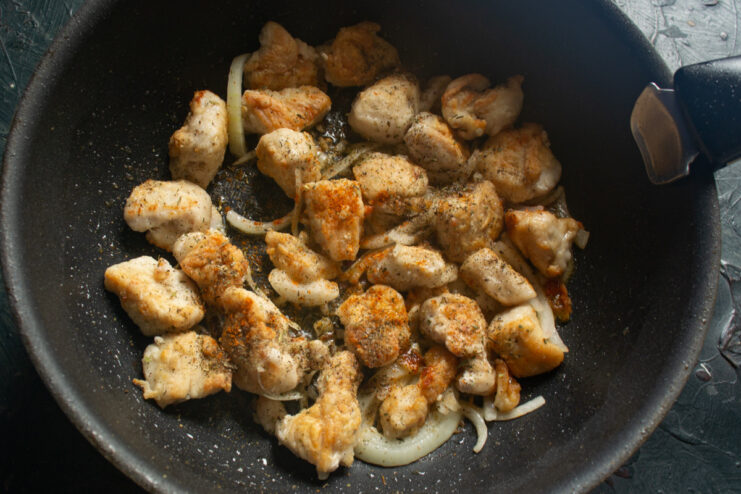 Deglazing the Wok with White Wine to Create a Flavorful Sauce Turkey, onions, and garlic being cooked in a wok with white wine.