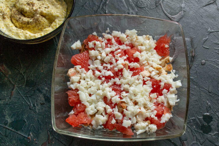Adding a layer of diced egg whites for texture. Adding a layer of finely diced hard-boiled egg whites to the salad.
