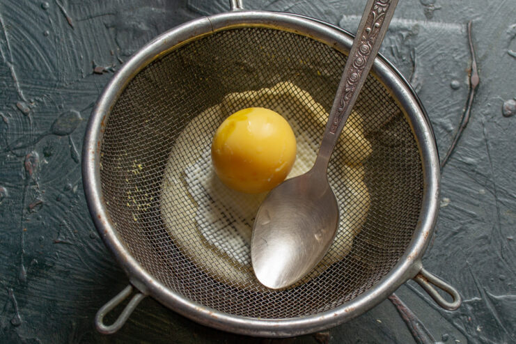 Separating egg yolks to create a smooth and creamy dressing base. Hard-boiled eggs being peeled, with yolks separated from the whites.