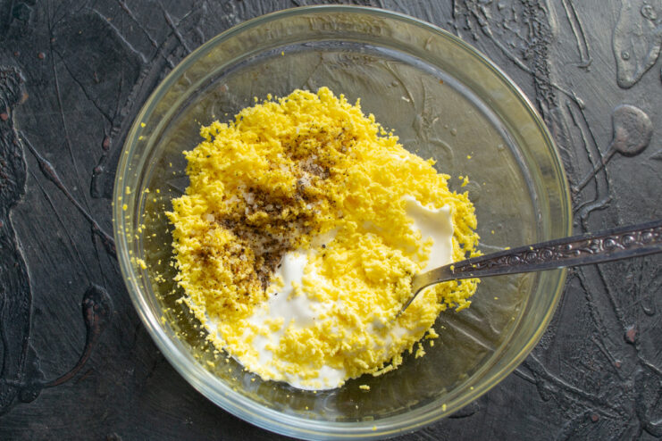 Preparing grated egg yolks for a creamy dressing Grated egg yolks in a small bowl for the salad dressing.