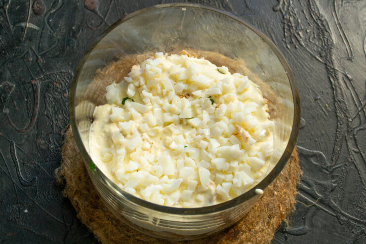 Adding diced egg whites for texture Finely diced hard-boiled egg whites in a bowl.