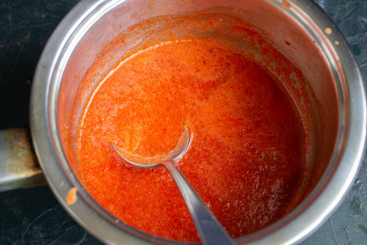 A pot of red vegetable sauce simmering on the stove.
