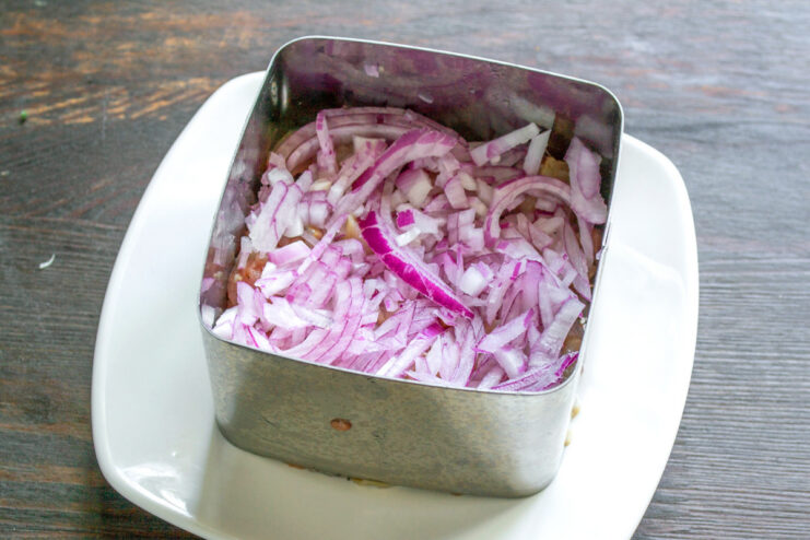 Preparing the Red Onion Layer A small bowl filled with finely diced red onion.