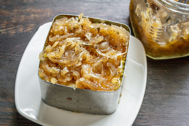 Adding the Secret Ingredient: Onion Jam Spreading a layer of dark, rich onion jam over the grated eggs in the salad.