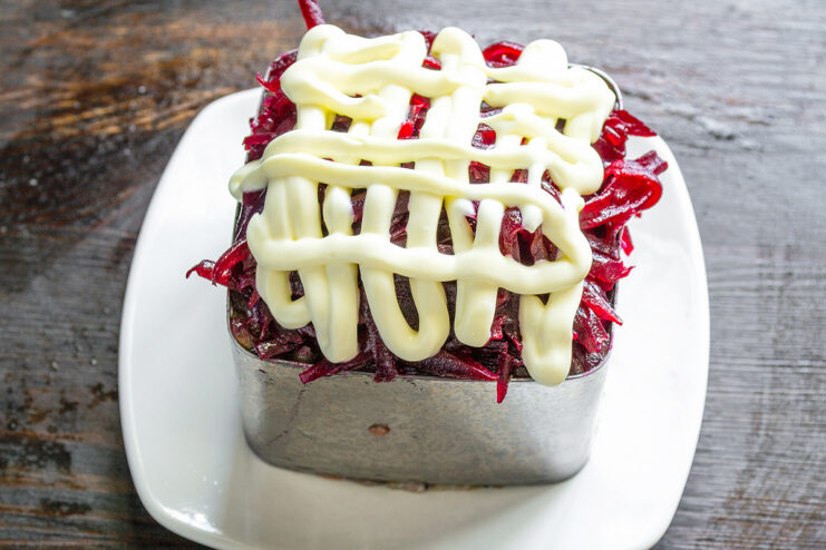 Finishing the Salad with a Top Layer of Mayonnaise Spreading the final, smooth layer of mayonnaise over the grated beets.