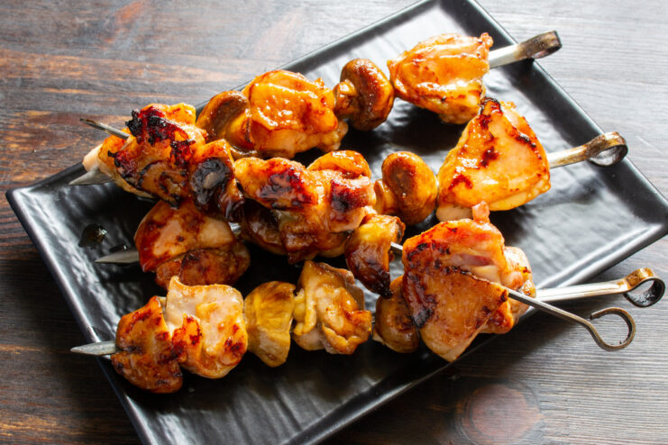 Serving Hot and Juicy Oven-Baked Chicken Skewers A close-up of freshly baked, golden-brown chicken and mushroom skewers on a plate.