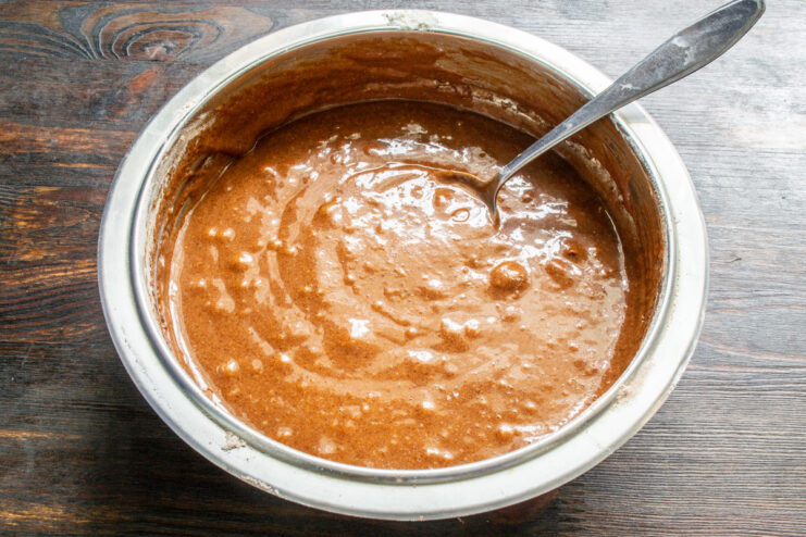 Step 5: Mixing the batter until smooth and uniform A smooth, rich chocolate muffin batter in a glass bowl after mixing.