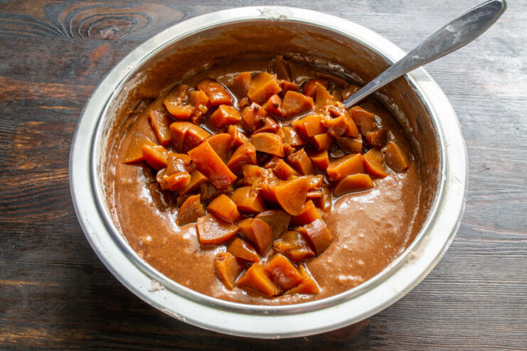 Step 6: Folding chopped canned peaches into the chocolate batter Adding diced canned peaches into the prepared chocolate muffin batter.
