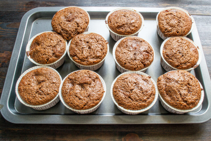 Step 8: Baking the chocolate peach muffins in the oven A batch of chocolate peach muffins baking in the oven until golden.