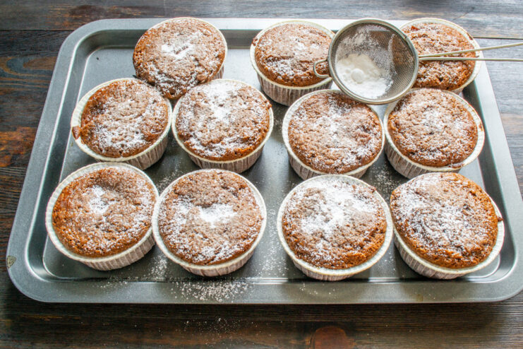 Step 9: Garnishing the baked muffins with powdered sugar Dusting freshly baked chocolate muffins with powdered sugar using a small sieve.