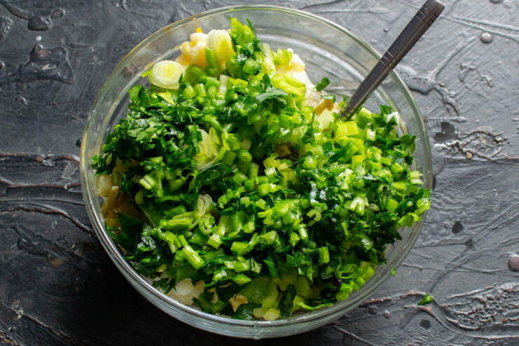 Fresh Herbs for a Vibrant Tartar Sauce Freshly chopped green onions and parsley on a cutting board for the tartar sauce.