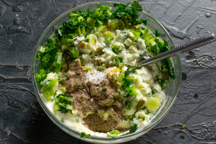 Seasoning the Tartar Sauce to Perfection Adding a pinch of salt and ground black pepper to the bowl of tartar sauce ingredients.