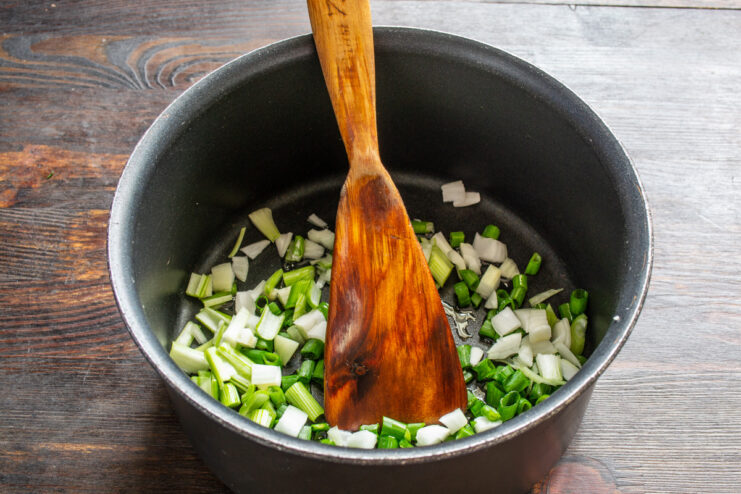 Starting the Flavor Base for Tomato Sauce Chopped onions and garlic being sautéed in a pan with olive oil.